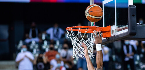 basketball going through the hoop at a sports arena - obrazy, fototapety, plakaty