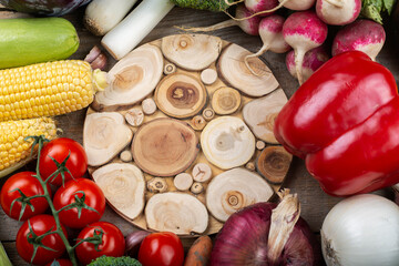 A vegetable background in the center of which is an empty cutting board. Healthy eating. Harvesting concept. Space for text.