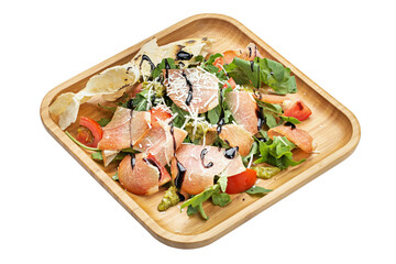 Salad with vegetables and cold cuts in a wooden plate isolated on white background.