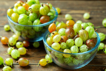 Ripe gooseberry in a glass plate, place for text, top view