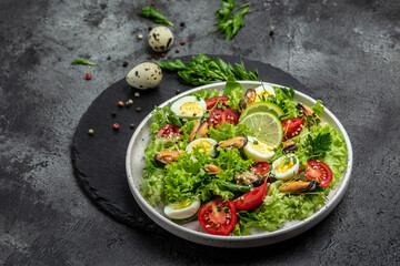 Healthy salad with mussels, quail, egg, conjugate, lime, spinach, lettuce, cherry tomatoes and microgreen. Keto lunch diet