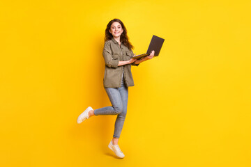 Full size portrait of cheerful person hands hold laptop look camera toothy smile isolated on yellow color background