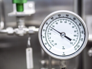 Temperature gauge for measuring instrument close up in industry zone at power plant.