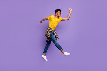 Fototapeta na wymiar Full length body size view of attractive cheerful glad guy jumping walking good mood isolated over violet purple color background