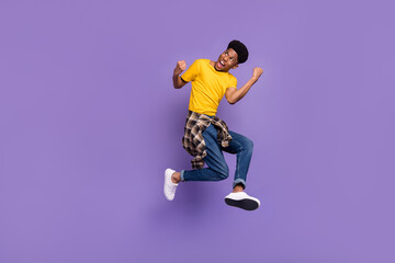 Fototapeta na wymiar Full length body size view of attractive cheerful successful guy jumping celebrating isolated over violet purple color background