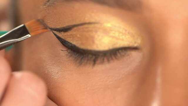 cropped view of african american woman applying black eye liner