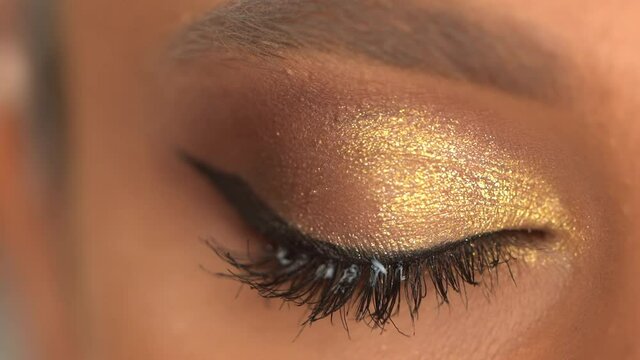 cropped view of african american woman applying eye shadow