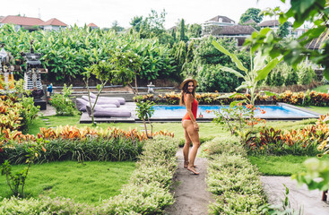 Content woman in swimwear near swimming pool