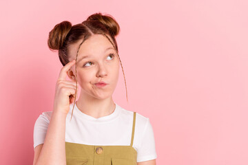 Portrait of attractive minded foxy girl touching temple overthinking copy space isolated over pink pastel color background