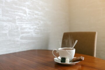a cup of hot tea on the table with cookie