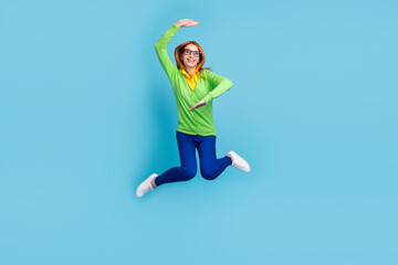 Full size photo of young crazy millennial lady jump wear spectacles sweater trousers isolated on blue color background