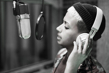 Female singer recording audio inside music studio
