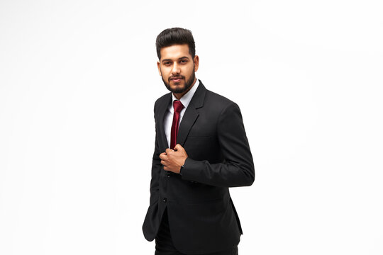 Portrait of young indian top manager in black suit on white isolated background and looking to the camera