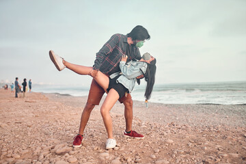 Pareja de jóvenes enamorados caminan por la playa durante un bello atardecer.. Jóvenes felices...