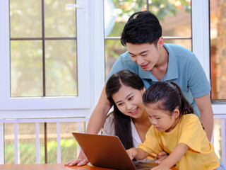 A Happy family of three using laptop