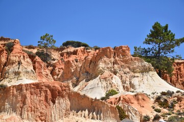 Fototapeta na wymiar Red cliffs on the beach of Praia da Falesia near Albufeira, Algarve, Portugal