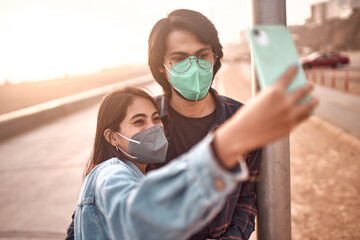 Pareja de jóvenes enamorados se toman fotografías selfies durante un bello atardecer.. Jóvenes...