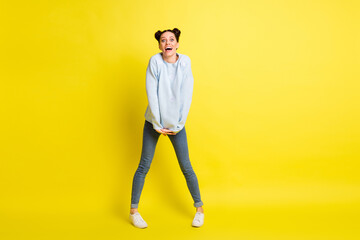 Fototapeta na wymiar Photo of shy lady hold hands open mouth look camera wear blue pullover jeans footwear isolated yellow background