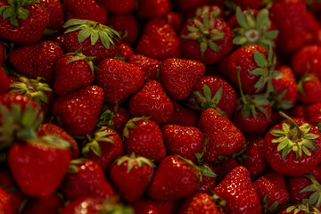 Lots of fresh bright strawberries on the market counter. Vitamins and healthy food. Top view. Background.