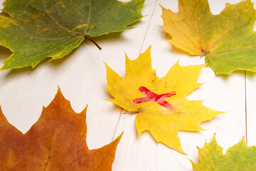 yellow sheet on a white wooden background with a red cross