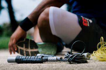 exercise ropes on the floor with athlete sitting behind her, for background and copy space, outdoor exercises