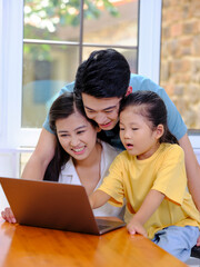 Fototapeta premium A Happy family of three using laptop