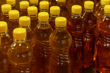 Homemade vegetable oil in plastic bottles on the market counter. Vitamins and healthy food.