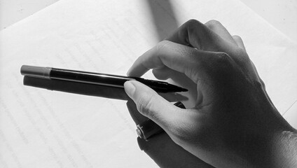 Photo of Asian holding a marker against a paper background