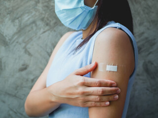 Woman showing her arm with bandage after receiving vaccine. immunization, inoculation and...