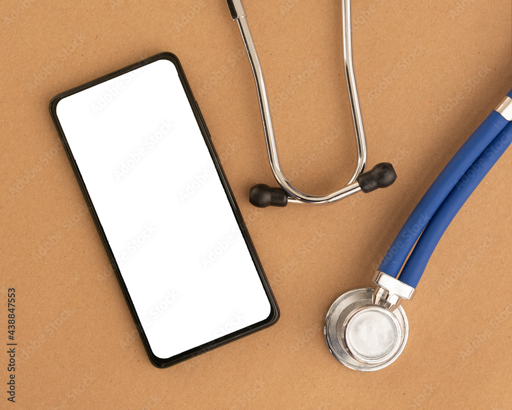 Leinwandbilder Mobile phone mock up with stethoscope. Template with white screen of smartphone at desk for medical application.
