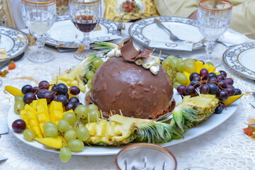 A plate of fruits. Mango, grape and pineapple. Frozen chocolate cake, fruity plate, served at wedding