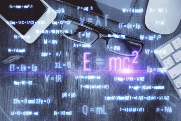 Double exposure of formula drawing over table with phone. Top view. Education concept.