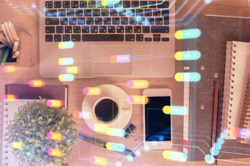 Double exposure of technology theme drawing over work table desktop. Top view. Global data analysis concept.