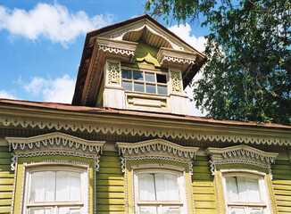 Part of the Facade with decor. Old Russian wooden house in an urban environment.