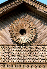 Part of pediment with decor. Old Russian wooden house in an urban environment.