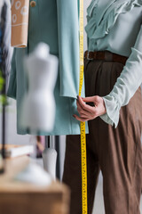 Cropped view of seamstress measuring blazer near mannequin - obrazy, fototapety, plakaty