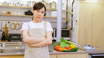 腕を組み真剣に献立に悩む家事代行の女性作業員
