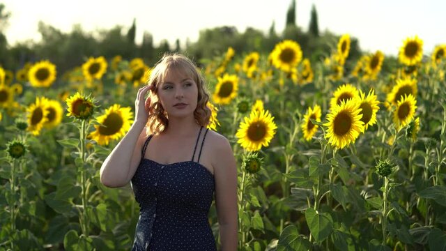 Chica joven guapa sonriendo y posando en un campo de girasoles
