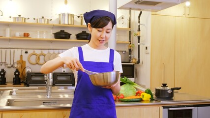 楽しそうに料理をする家事代行の女性作業員