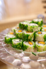 rolls with green algae on a tray in a restaurant.