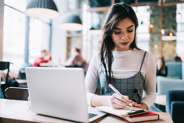 Calm woman writing notes on clipboard