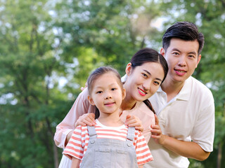 Happy family of three playing in the park