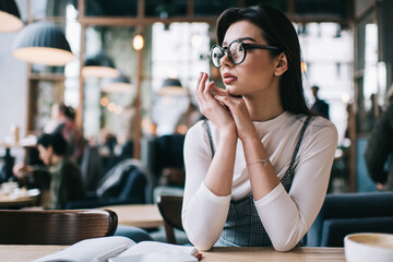 Pensive woman in cafe looking away