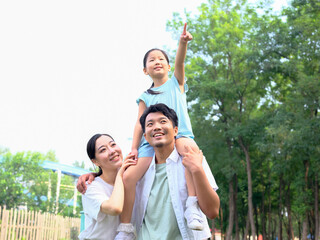 Happy family of three playing in the park