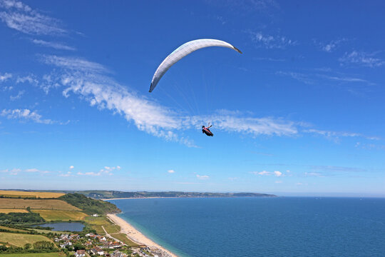 Paraglider flying above Beesands beach in Devon, England