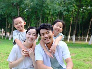 Happy family of four playing in the park