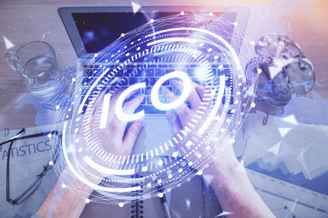 Double exposure of man's hands typing over computer keyboard and crypto currency theme hologram...
