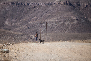 shirtless man accompanied by his dog in the desert mountains of Mexico
