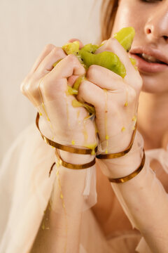 Fashion model crumples kiwi in her hands