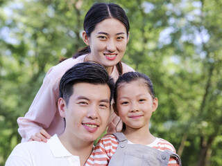 Happy family of three playing in the park